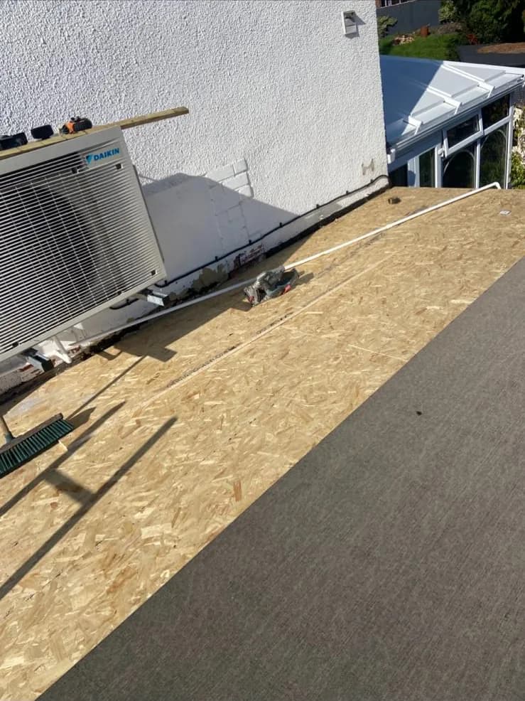 New OSB flat roof deck with first layer of felt